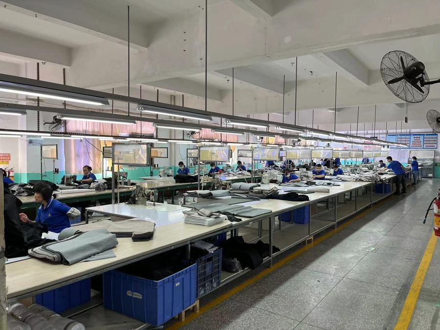 The sewing floor, with long tables of machinists